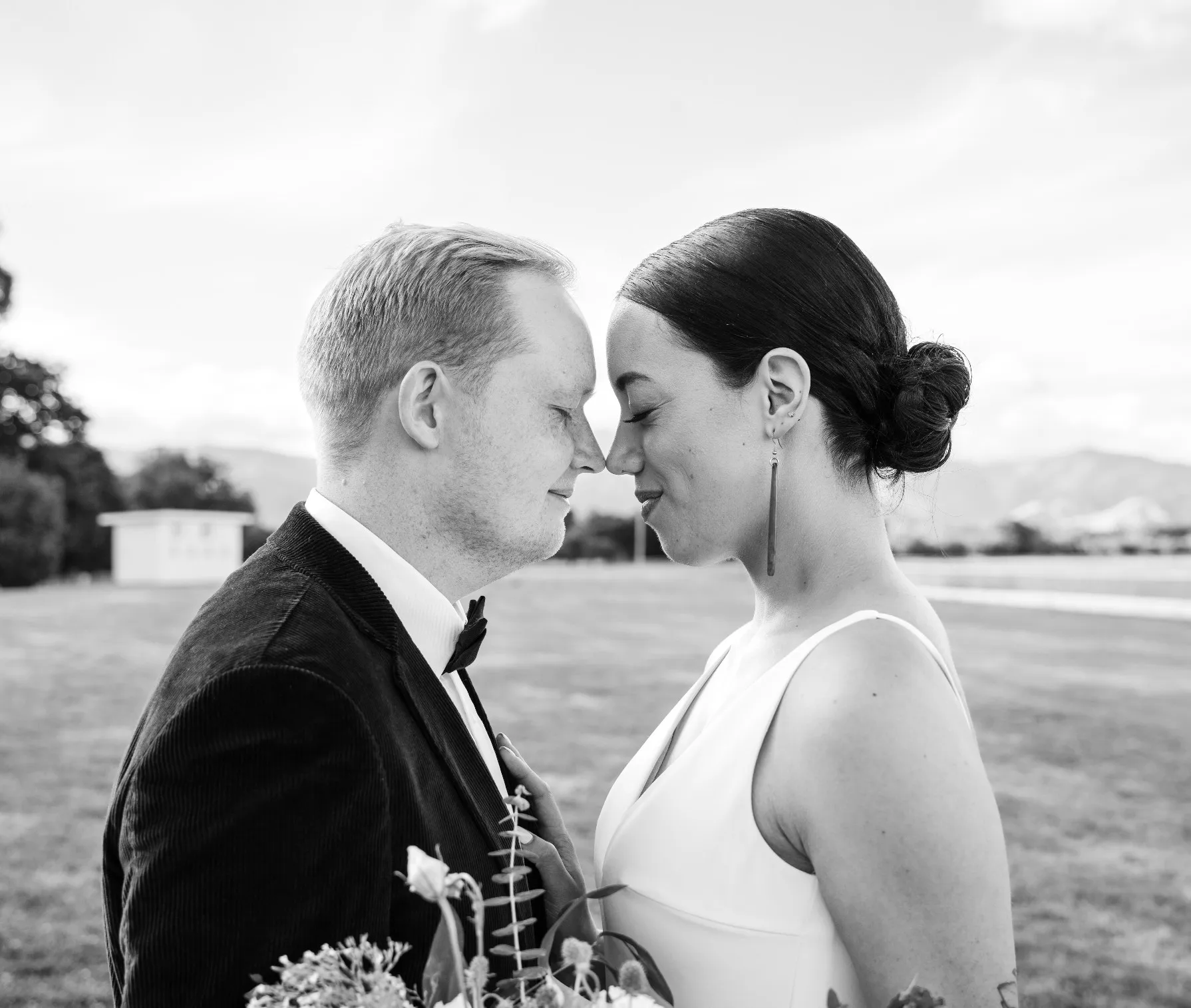 Black and white portrait of a bride and groom touching foreheads