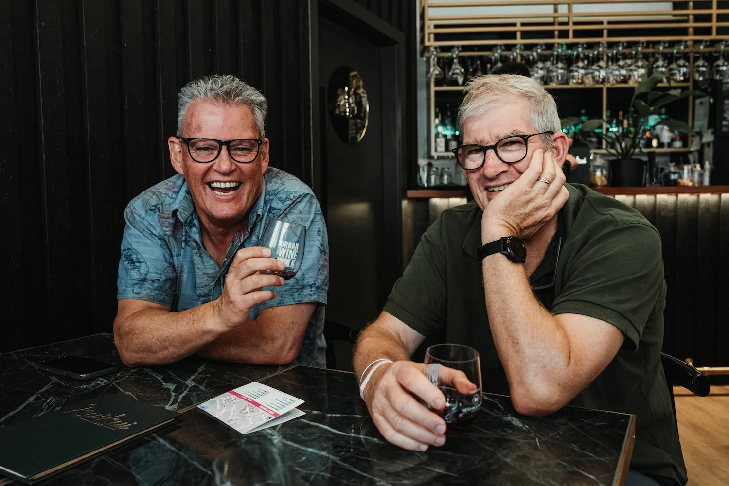 Two wedding guests laughing at a table