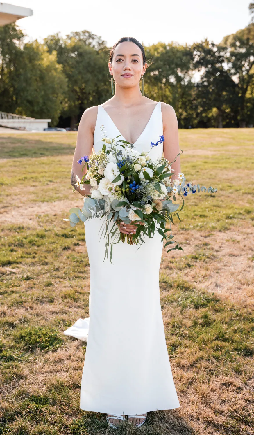 Bride holding her bouquet on a sunny lawn